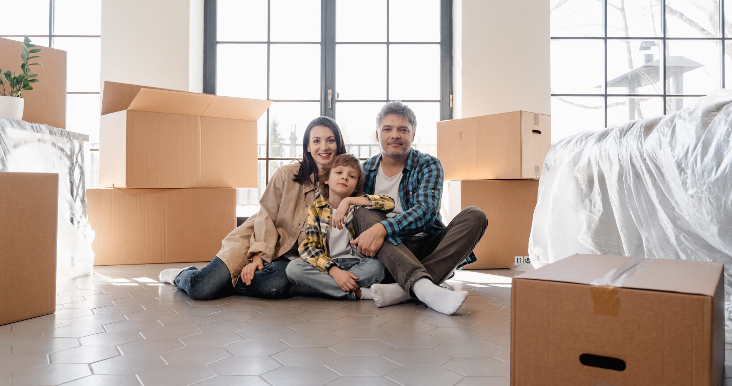 couple with children sitting on the floor with boxes